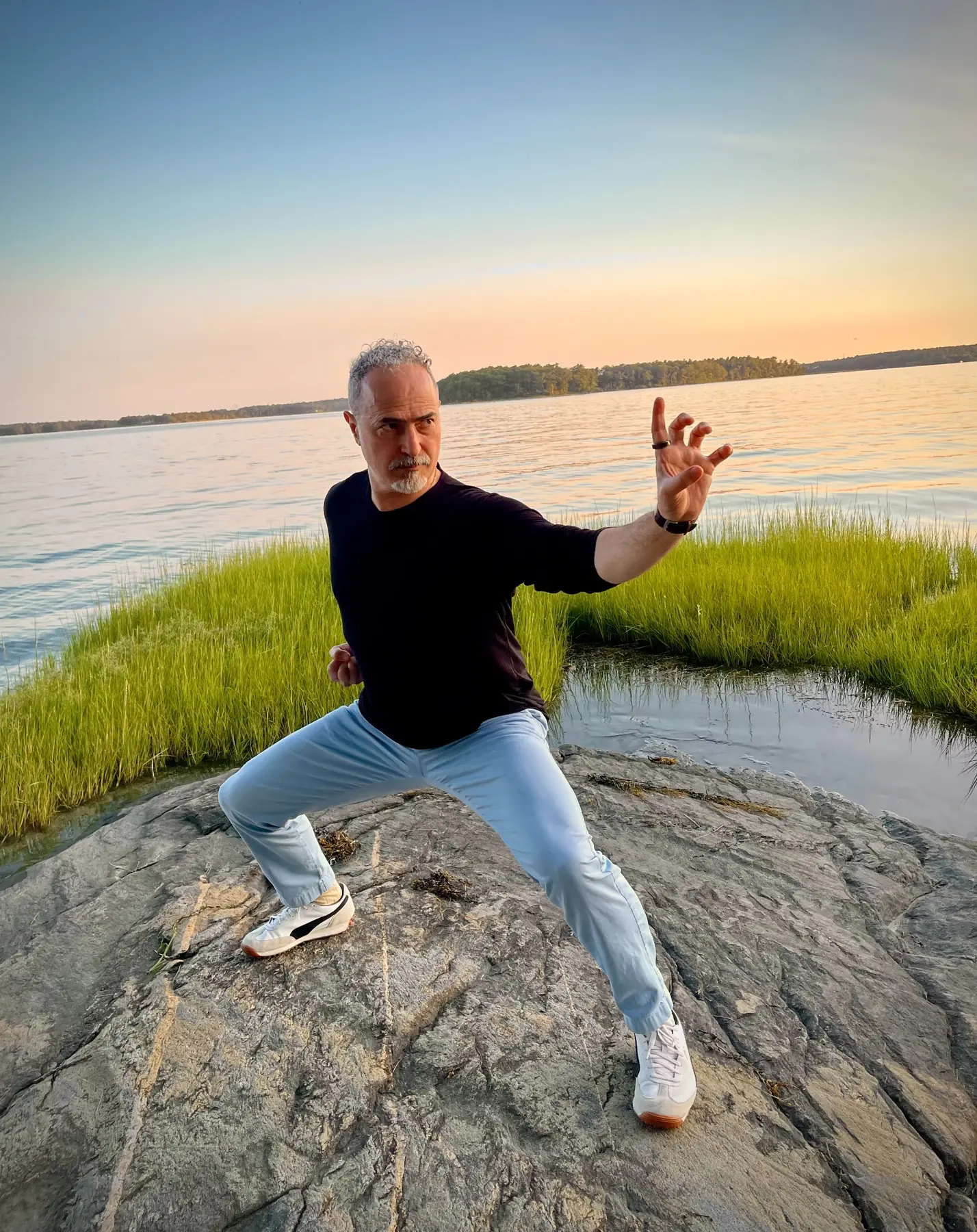 Jack Yee holding a Hung Gar hand position beside the water in the Berkshire Mountains