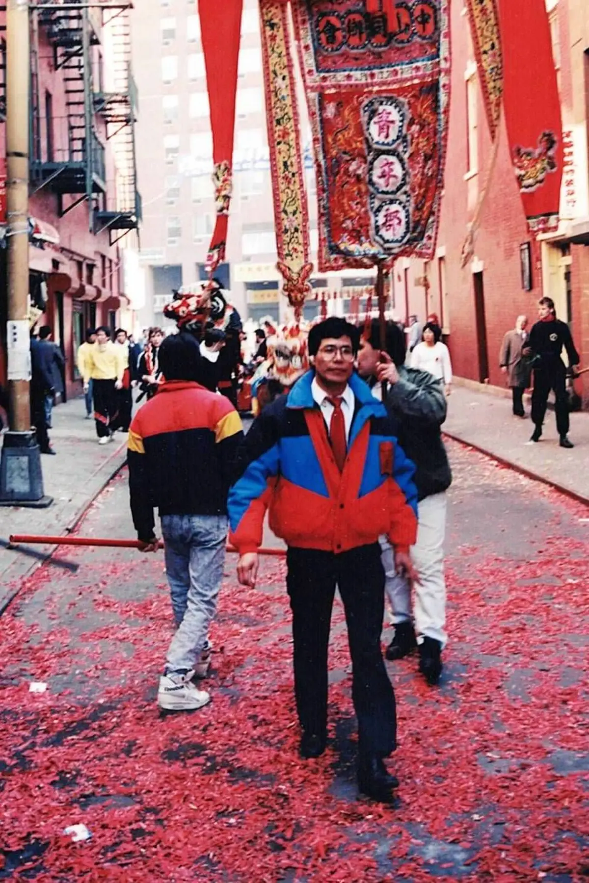 Ceremonial banners carried through a Chinatown street after a Lion Dance procession