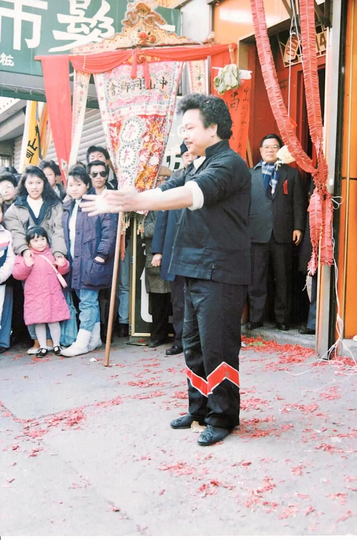 Sifu Tony Lau standing before a decorated Chinatown doorway during a Lion Dance celebration